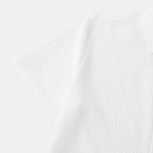 Macro view of white jacquard textured fabric on a men's short-sleeve summer shirt.