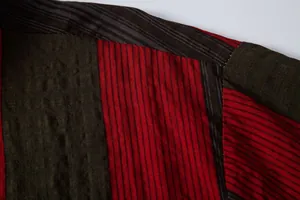 Gros plan de la texture du tissu rayé rouge et vert sur une chemise décontractée.