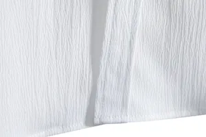 Detailed macro shot of white crinkle fabric texture and hem stitching on men's shirt