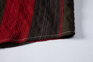 Gros plan macro sur l'ourlet d'une chemise à rayures rouges avec coutures blanches