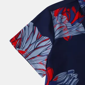 Gros plan du revers de manche courte sur une chemise marine à motif floral rouge.