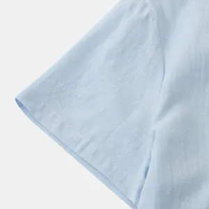 Close-up view of the light blue linen-blend short sleeve showing neat stitching and texture