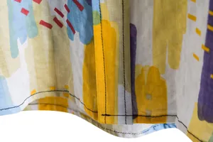 Close-up detail of high-quality stitching and abstract colorful print on men's casual shirt
