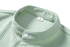 Detail of mint green textured men's casual shirt featuring a stand collar and button