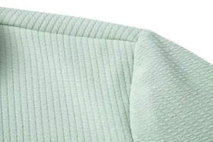 Macro detail of mint green shirt showing vertical ribbed fabric texture and shoulder seam