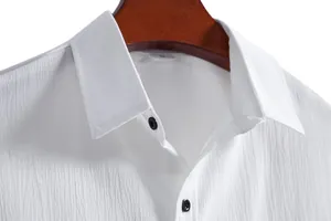 Close-up detail of a white men's shirt collar with vertical crinkle texture and dark buttons