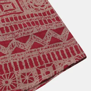Close-up van rode etnische print stof en zoom stiksel op een heren shirt met korte mouwen