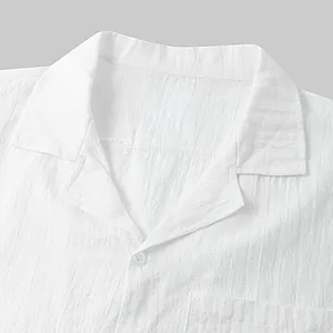 Close-up of white cotton linen shirt collar with button detail and fabric texture