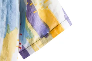 Close-up detail of a colorful abstract floral print on a men's summer casual shirt sleeve.