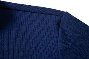Close-up of deep blue textured fabric and stitching on a men's casual shirt.