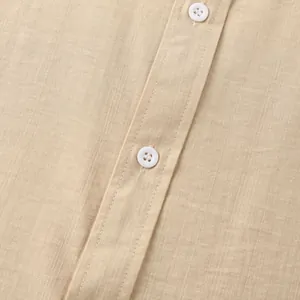 Close-up van beige herenoverhemd met linnen textuur en witte knopen op de sluiting
