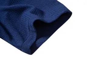 Macro detail of deep blue textured fabric on men's short-sleeve casual shirt hem