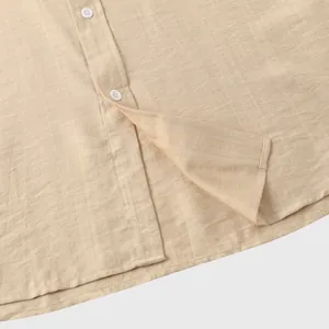 Close-up van de stoftextuur en witte knopen van een beige herenoverhemd in linnenstijl