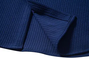 Macro shot of navy blue waffle texture fabric and hem split detail on men's shirt.