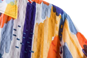 Close-up macro view showing texture and colorful abstract floral pattern on men's casual shirt