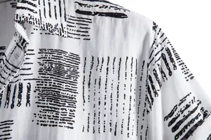 Macro detail of white casual shirt showing black abstract geometric line pattern and fabric texture