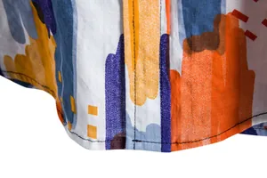 Close-up detail of casual short-sleeved shirt featuring abstract colorful paint stroke print