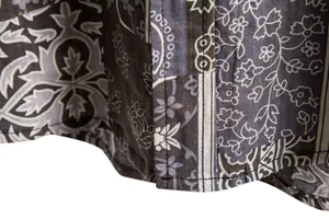 Detailed macro view of the hem and floral pattern on a casual men's short sleeve shirt.