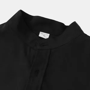 Detalle de primer plano del cuello de una camisa negra de algodón y lino con etiqueta de talla M