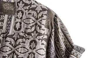 Macro view of the intricate ethnic floral print on a men's brown short sleeve shirt