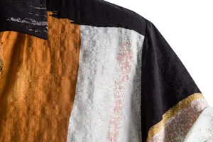 Detail shot of men's casual shirt showing color-block pattern and linen fabric texture