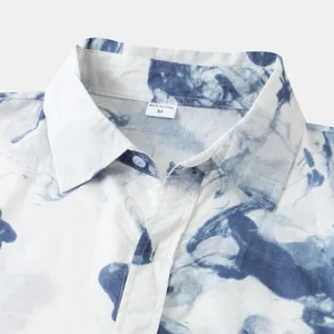 Macro detail shot of men's blue and white tie-dye shirt collar with size M label