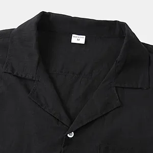Close-up detail of a black cotton linen shirt collar featuring a size M label tag