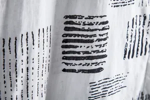 Macro detail of breathable white fabric with black hand-drawn abstract stripe pattern