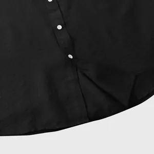 Detailopname van zwart herenshirt met korte mouwen, witte knopen en linnen textuur.