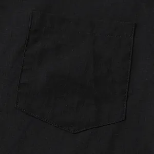 Close-up macro view of a black cotton linen shirt pocket showing rich fabric texture