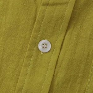 Close-up detail of mustard yellow cotton linen fabric texture and white button