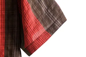 Close-up detail of a plaid short sleeve shirt showing fabric texture and sleeve cuff