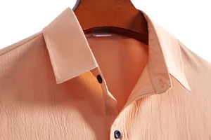 Close-up detail of peach textured fabric and collar on a men's casual shirt