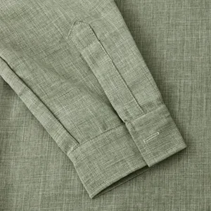 Close-up detail of olive green cotton linen shirt sleeve showing fabric texture and cuff.