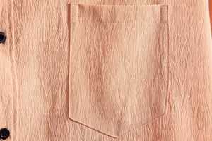 Close-up detail of men's casual shirt showing textured fabric and pocket stitching