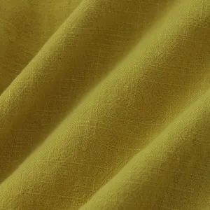 Macro shot of mustard yellow cotton linen shirt fabric texture with breathable weave.