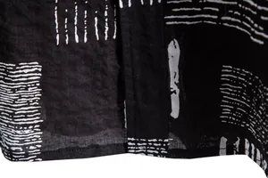 Macro shot of black shirt fabric featuring white abstract geometric print and stitching.