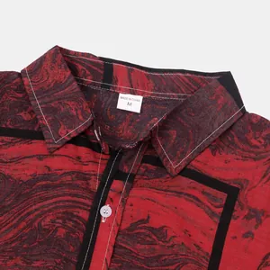 Detailaufnahme des Kragens eines roten Hemdes mit Marmordruck und Etikett Größe M