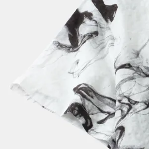 Close-up detail of a white Hawaiian shirt sleeve with black abstract ink print