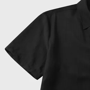 Gedetailleerde close-up van de zwarte linnen stoftextuur op een herenshirt met korte mouwen