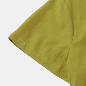 Close-up detail of a mustard yellow cotton linen short sleeve shirt fabric texture