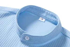 Close-up of light blue textured shirt collar with white button and S size tag detail