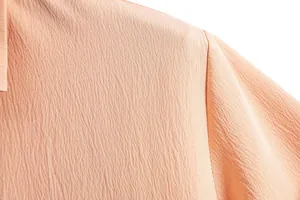 Close-up macro view of peach crinkle fabric texture on men's short sleeve shirt