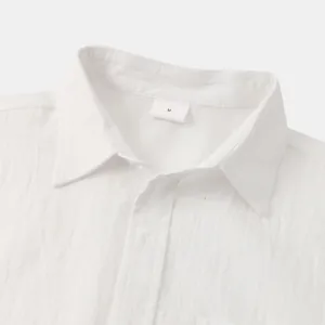 Close-up detail of a white cotton linen shirt collar with an M size tag and buttons
