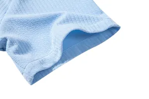 Close-up of light blue ribbed fabric texture on a men's short sleeve casual shirt.