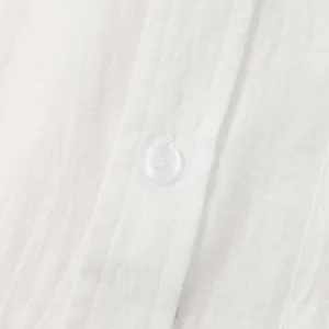 Macro view of white cotton linen shirt showing fabric texture and button detail