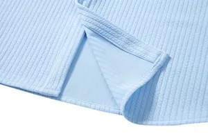 Close-up detail of the side slit and ribbed texture on a light blue men's casual shirt.