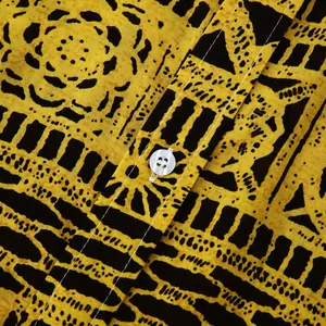 Detail van etnisch geel en zwart bloemenpatroon op herenoverhemd met knoopdetail