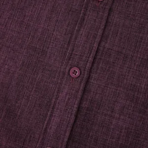 Macro detail of plum linen-blend men's shirt fabric texture and button closure