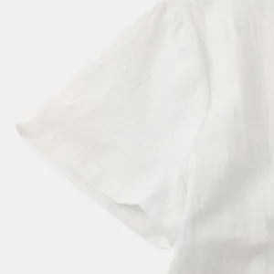 Close-up of white cotton linen shirt sleeve showing fabric texture and fine stitching